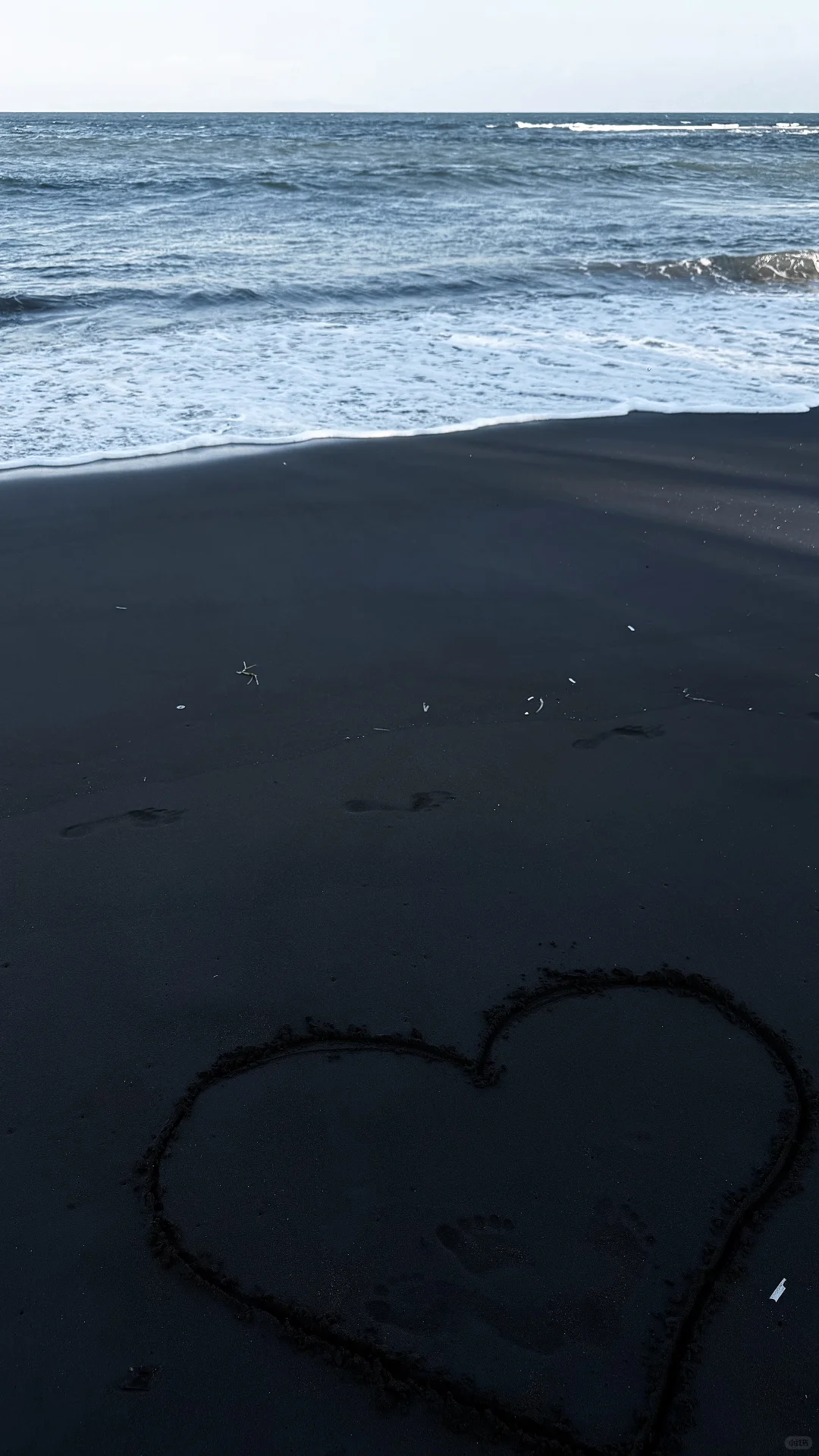 在黑沙滩留下一抹玫红色