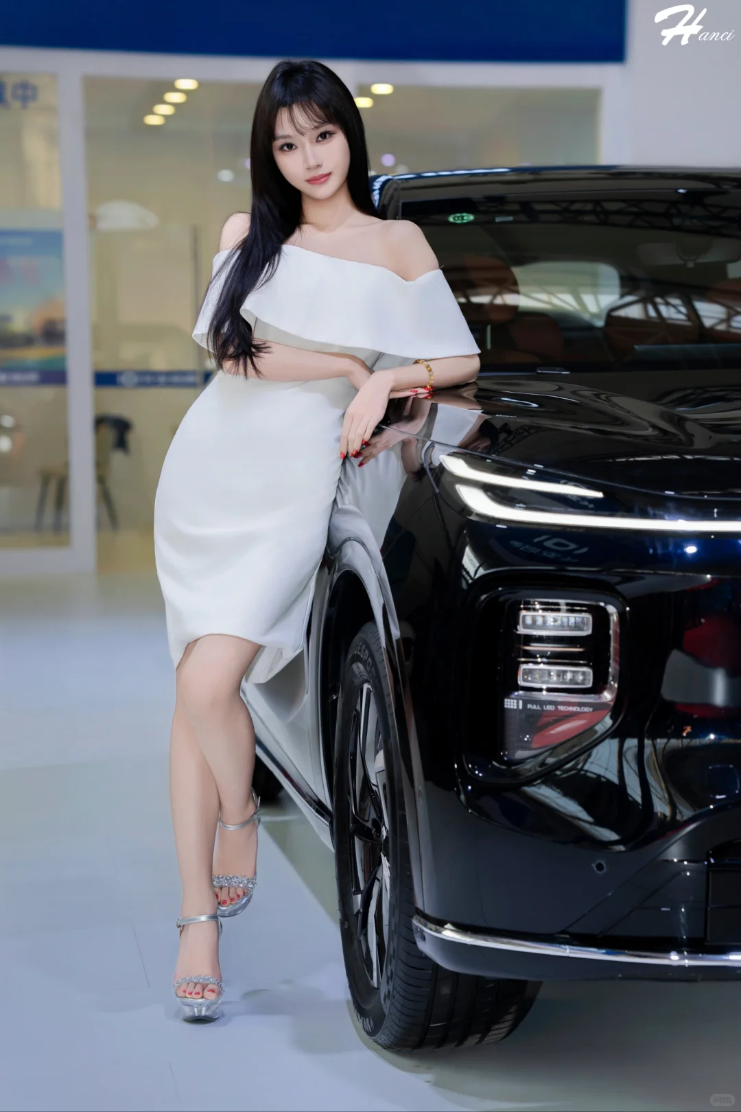 哈尔滨秋季车展上模特十七身穿白裙展示美姿